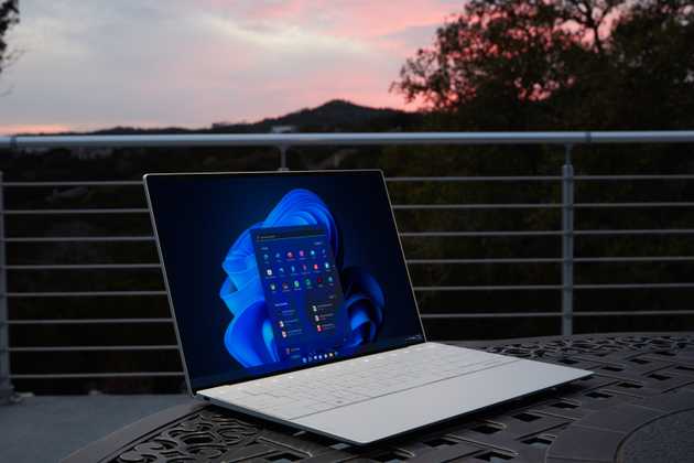 A Windows Laptop in front of an evening view of a hill